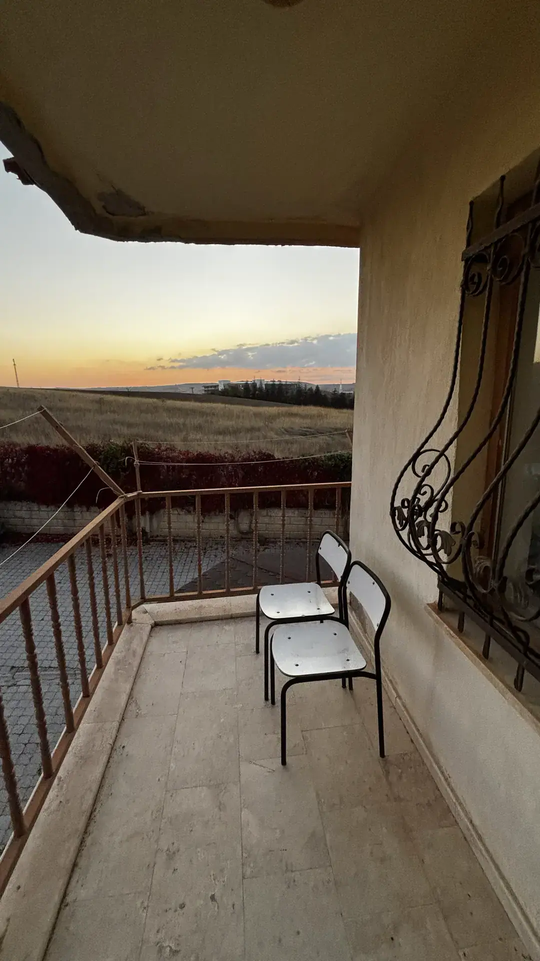 Üst kat balkonundan tarlalara ve gün batımına bakış